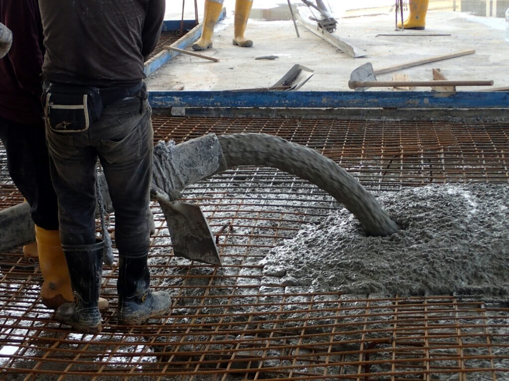 Construction worker pouring concrete for a building floor slab